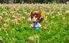 Anime doll standing in the grass with a cute smile