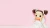Cute wedding doll with brown hair infront of a pink background