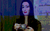 Morticia Addams drinking coffee with a sly look